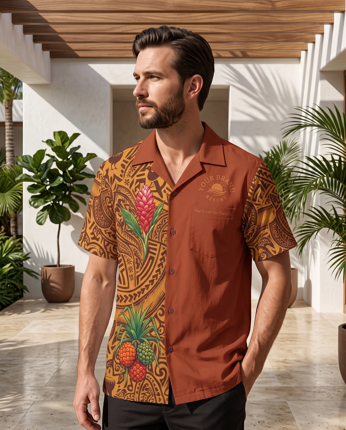 A man wearing a short-sleeve camp collar button-up shirt with a split design: one side is rust brown, and the other features a tan and brown Polynesian tribal pattern with tropical fruit prints including pineapples and red flowers. The shirt has 'Tropical Island Vibes' printed on the chest.