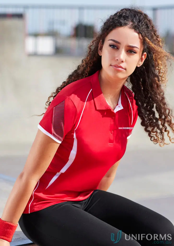 Woman modeling red ladies polo shirt with white accents and black leggings for polyester sports or uniforms