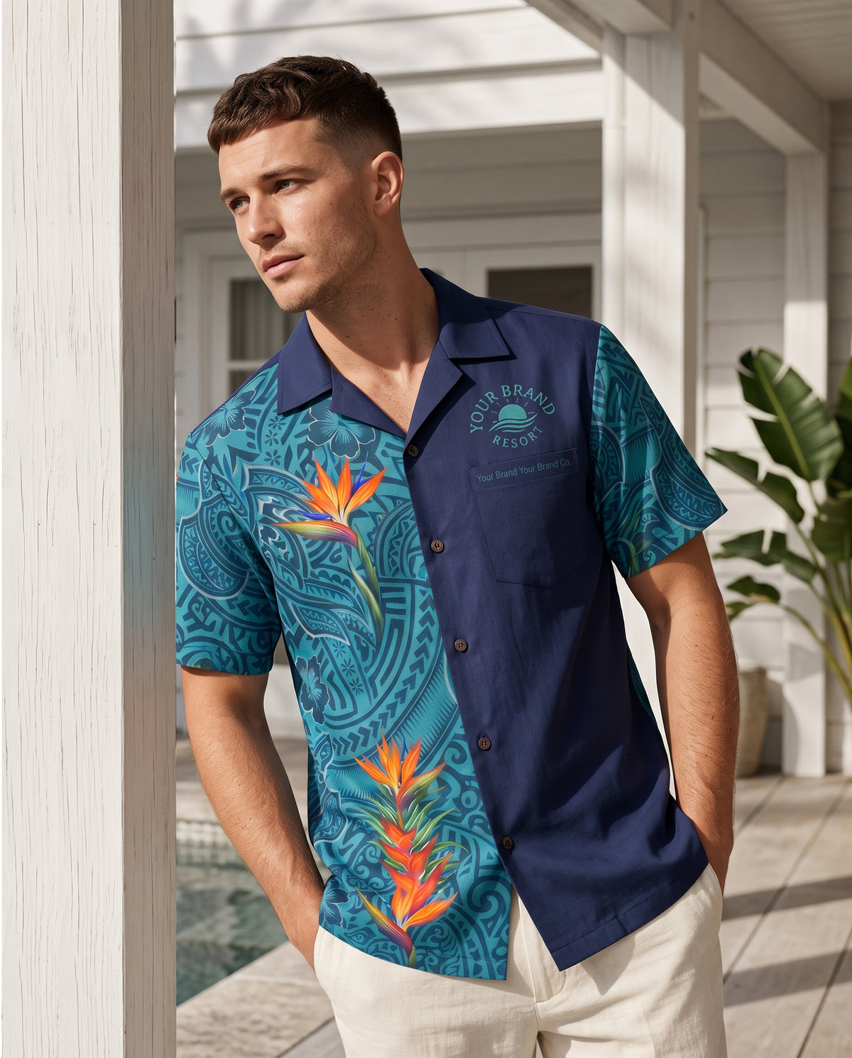 A man wearing a short-sleeve button-up camp shirt with a split design: one side features a teal and blue tropical floral and paisley print, while the other side is solid navy blue. The shirt has 'South Beach Collection' printed on the chest.