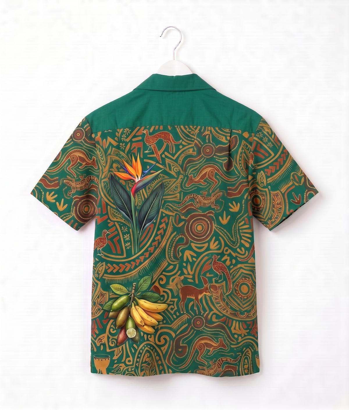 A short-sleeve camp collar shirt with a green yoke and a highly detailed, colorful tribal-style print on the body, featuring a bird of paradise flower, bananas, and abstract motifs. The shirt is shown hanging on a white plastic hanger against a white background.