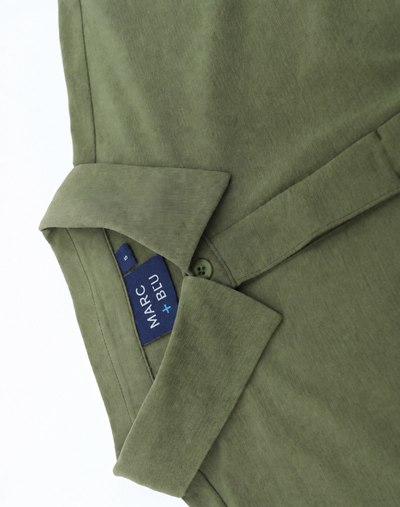 Close-up of an olive green shirt with a collar and a blue Marc + Bleu brand tag visible inside the collar.